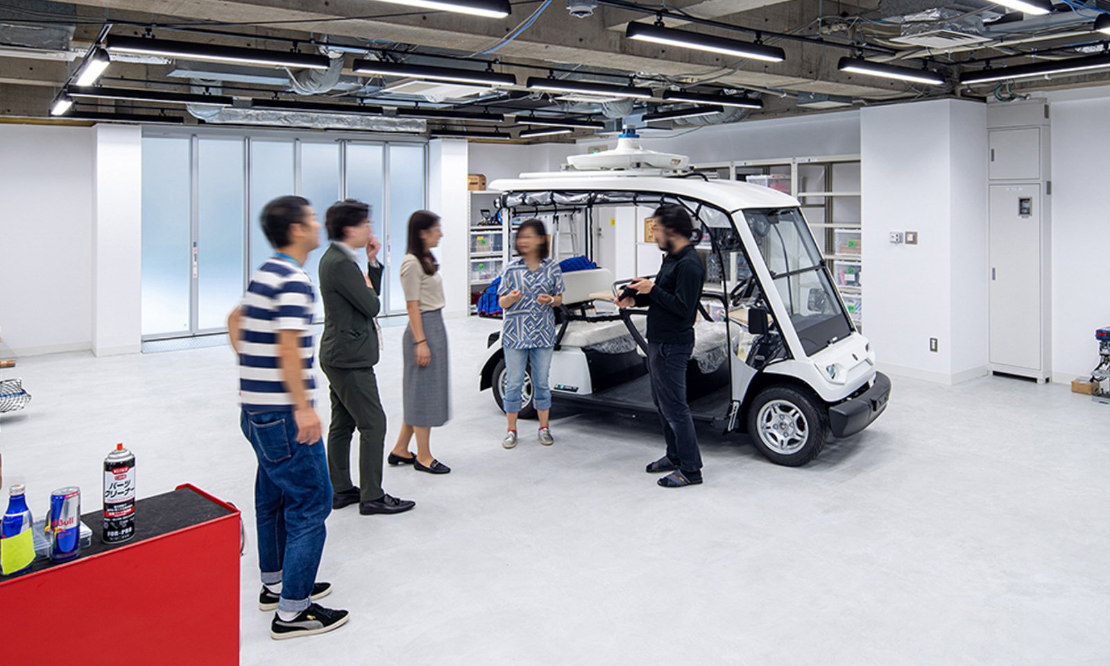 車庫で車両について議論するティアフォーのエンジニア